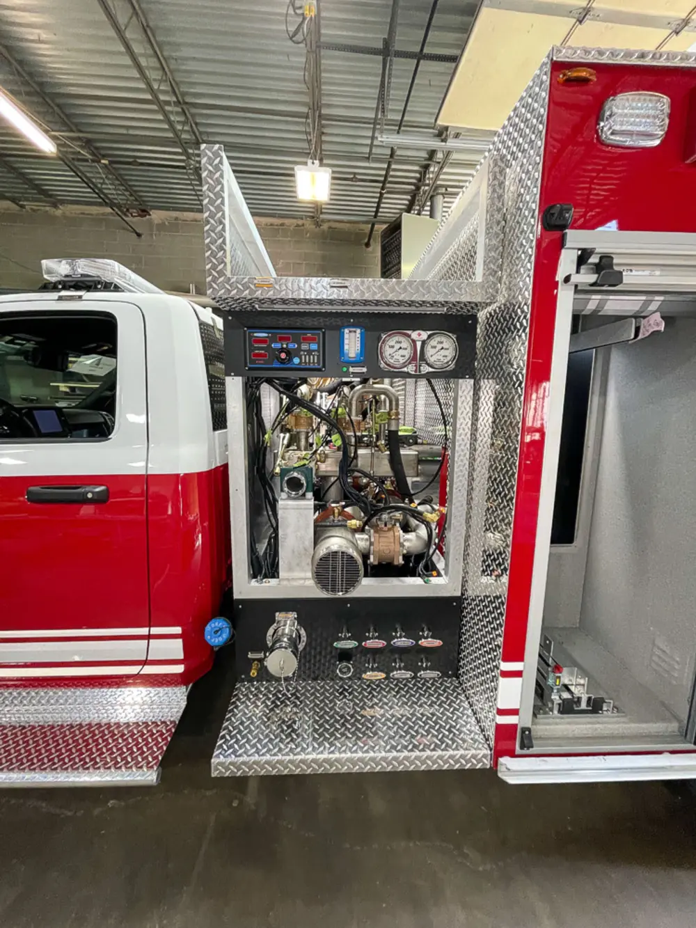 Exterior view of small fire truck showing cab, body compartments, and wheel/tire area.